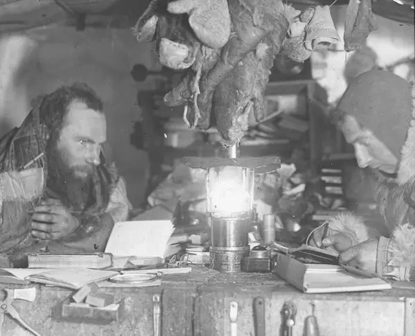 Two expedition members in an ice cave by lamplight, 1930–31