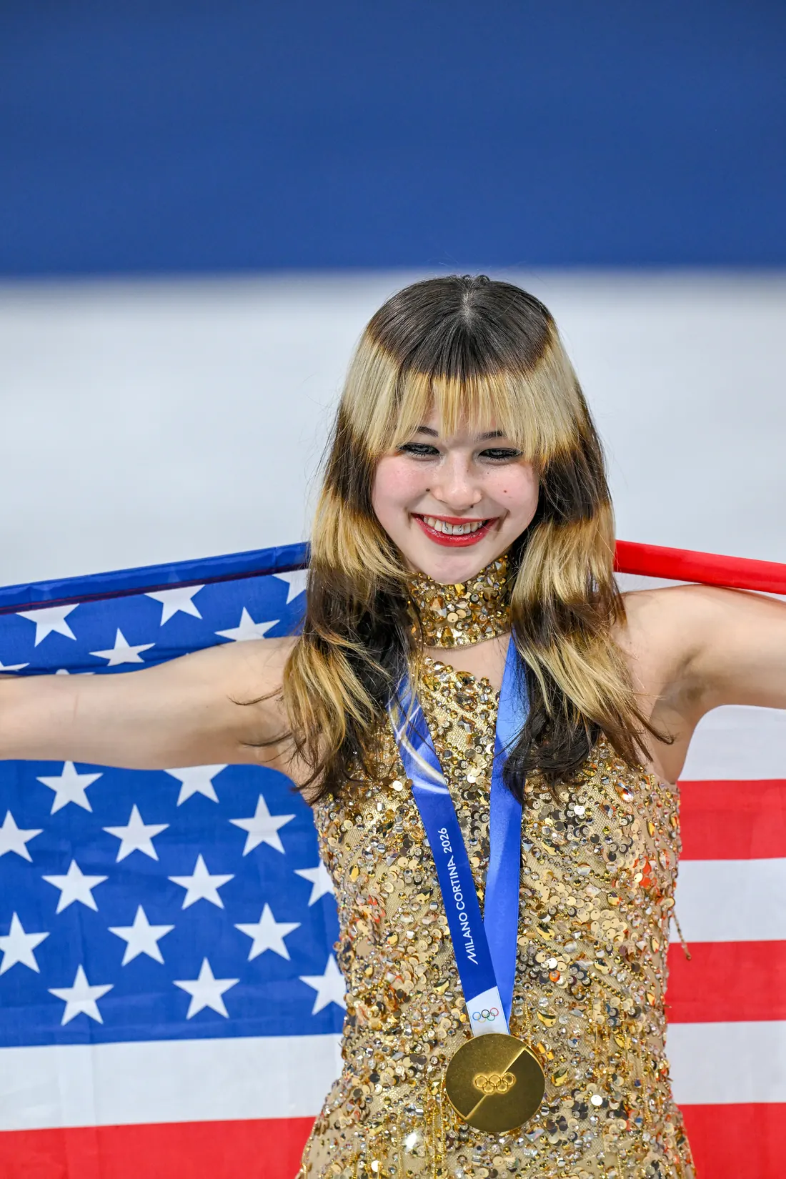 Alysa Liu with her gold medal and the US flag at the Olympic medal ceremony, Milan, February 19, 2026 (cropped)