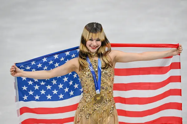 Alysa Liu holds up the US flag at the Olympic medal ceremony, Milan, February 19, 2026 (cropped)