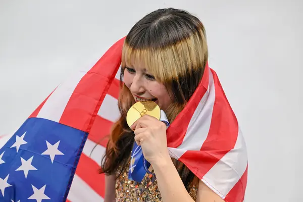 Alysa Liu bites her Olympic gold medal, Milan, February 19, 2026 (cropped)