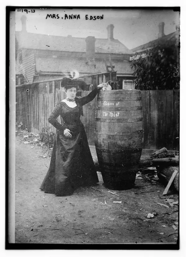 Mrs. Anna Edson standing next to huge barrel upon which is written "Queen of the Mist" and upon which is sitting a cat LCCN2014685568