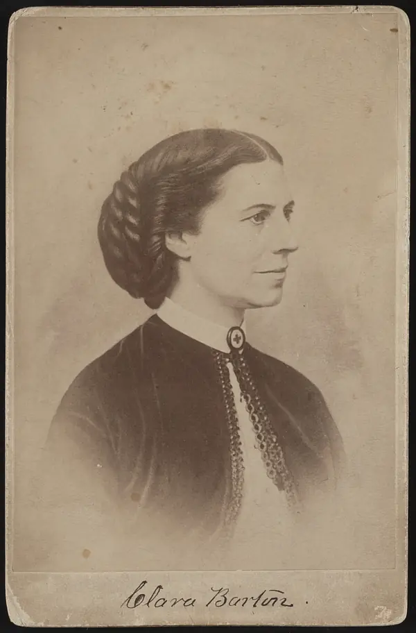 Clara Barton with a Red Cross brooch, a cabinet card she signed (the Library of Congress dates the photo about 1865)