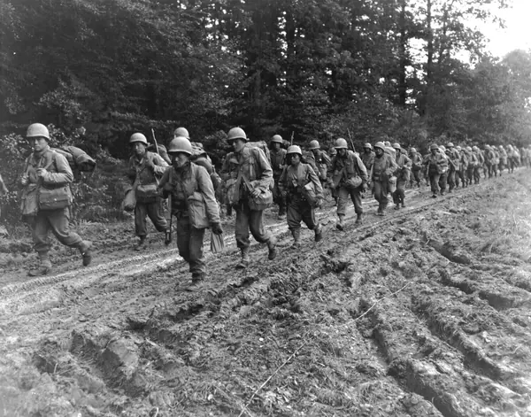 442nd infantrymen hike up a muddy road in France, late 1944 (Inouye isn’t shown)