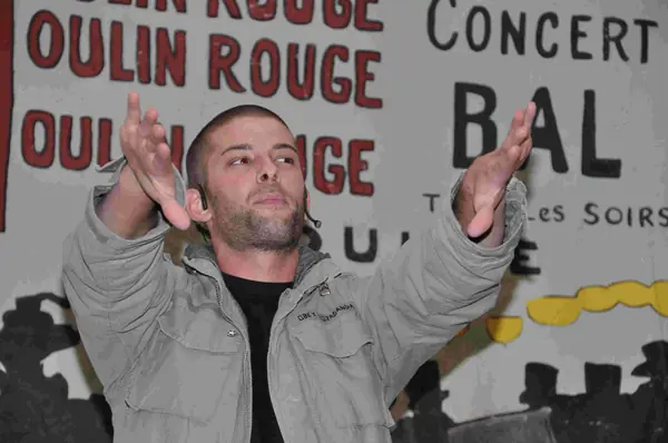 Darcy Oake with his arms raised at the “All That Glitters” charity gala, May 7, 2010 (not the 2019 show)