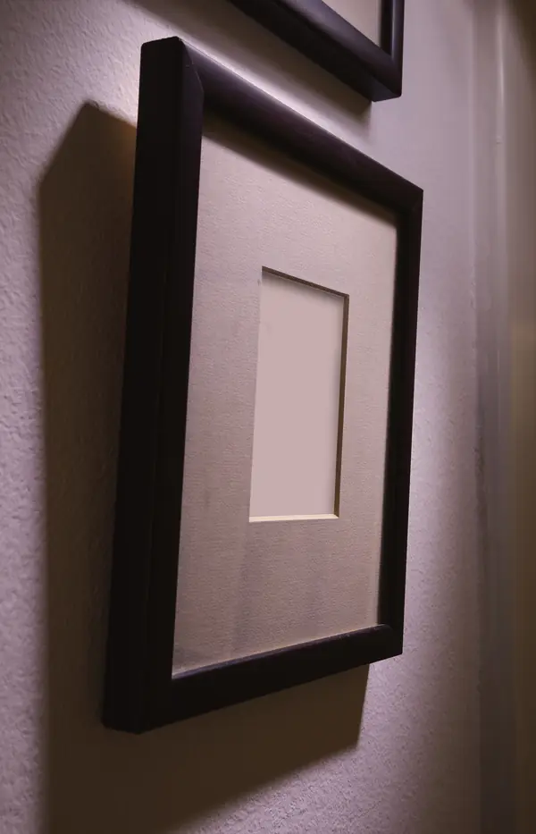 An empty picture frame on a wall, 2022 (a symbol, not the family’s photo)