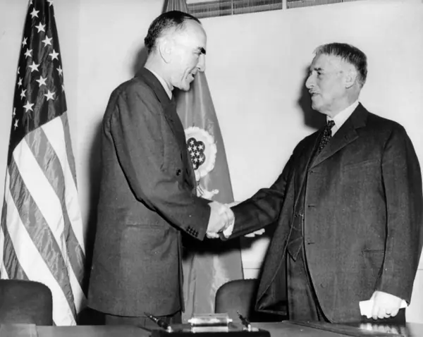 Rickenbacker (left) shaking hands with Secretary of War Henry L. Stimson, December 19, 1942, after the rescue