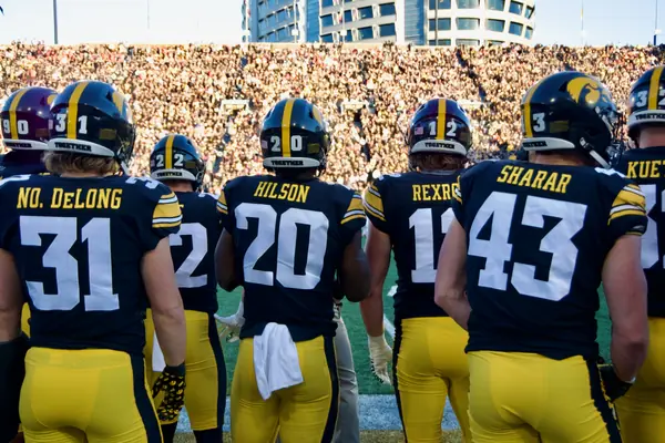 Iowa’s players face the stands, with the hospital tower above, Kinnick Stadium, November 18, 2023