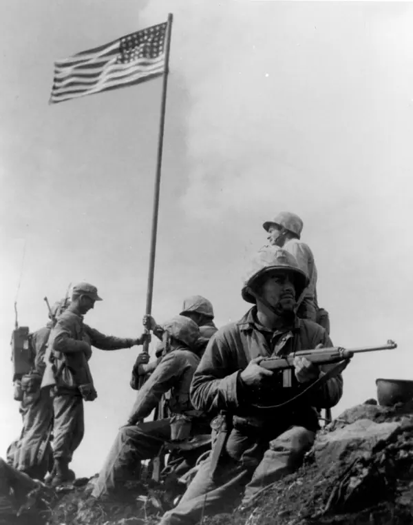 The first, small flag on Mount Suribachi, February 23, 1945, photographed by SSgt. Louis R. Lowery, USMC