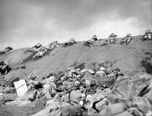 Fifth Division Marine invaders of Iwo Jima work their way up the slope from Red Beach One. (49672876132)