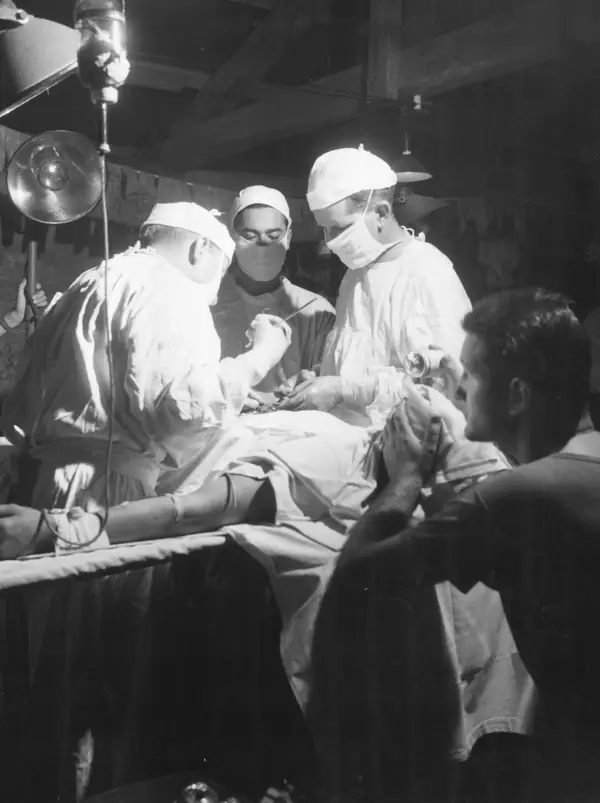 Navy doctors operate to remove shrapnel from the abdomen of a wounded Leatherneck at the 4th Marine Division evacuation hospital. (49672862676)