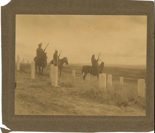 White Man Runs Him, Hairy Moccasin and Goes Ahead on horseback among the markers on the Little Bighorn battlefield, photographed by Richard Throssel, about 1908–09