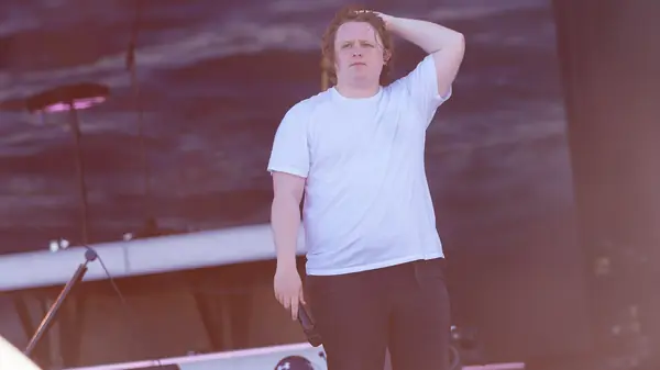 Lewis Capaldi with a hand on his head near the end of his set, Pyramid Stage, Glastonbury, June 24, 2023