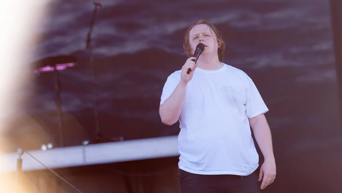 Lewis Capaldi singing into a hand mic near the end of his set, Pyramid Stage, Glastonbury, June 24, 2023