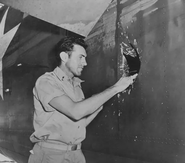 1st Lt. Louis Zamperini at a 20 mm shell hole in the B-24D Super Man after the Nauru raid, Funafuti, April 1943 (not the bomber that crashed)