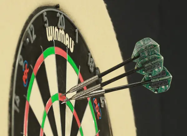 A dartboard with three darts at a Premier League Darts night, Berlin, April 3, 2025 (cropped)