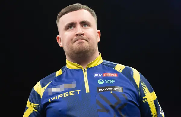Luke Littler looking up at a Premier League Darts night, Berlin, March 26, 2026 (cropped; logo pixelated; not a World Championship)