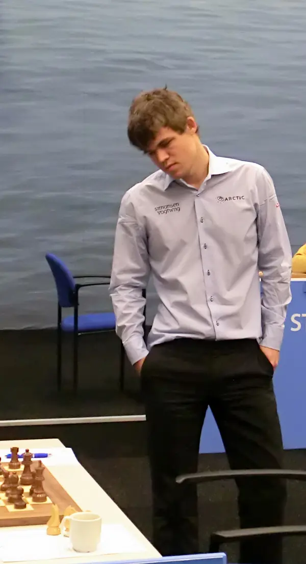 Magnus Carlsen standing with his eyes down, Tata Steel tournament, Wijk aan Zee, January 2013 (not Harvard)