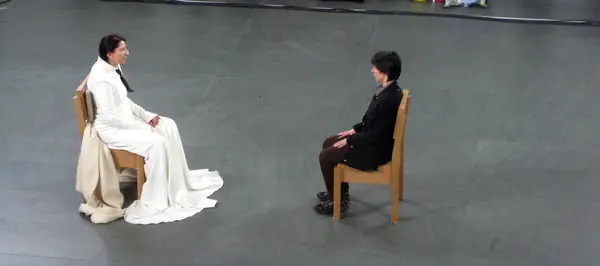 Marina Abramović facing a sitter, a museum visitor, in MoMA’s atrium, May 9, 2010 (not the opening night)