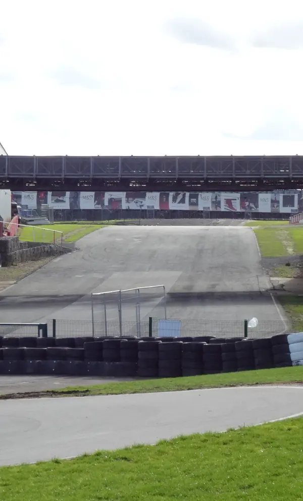 The hairpin under the bridge at Kart Silverstone, October 22, 2026, a month after Max vs 100 (not the race)