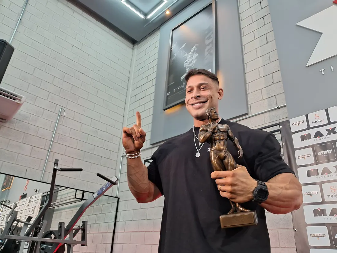 Ramon Dino smiling with the 2025 Olympia trophy at the same event in Brazil, October 16, 2025 (not the moment he won)