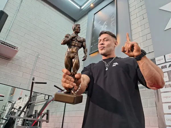 Ramon Dino with the 2025 Classic Physique Olympia trophy at a sponsor event in Brazil, October 16, 2025 (five days after the win, not the moment)